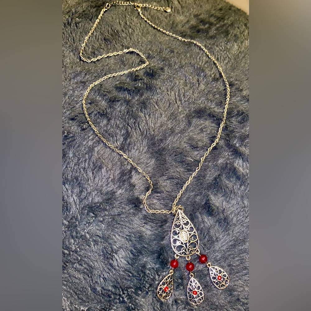 Silver tone Necklace with silver pendant w/ red accents .  Hangs 18”